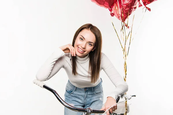 Woman leaning on bike with balloons — Stock Photo
