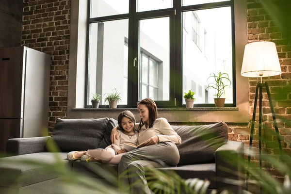 Family reading book together — Stock Photo