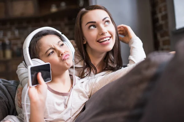 Tochter hört Musik über Kopfhörer — Stockfoto