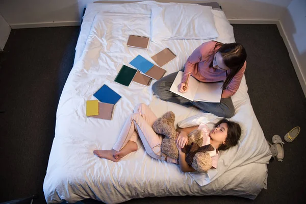 Daughter sleeping and mother working at night — Stock Photo