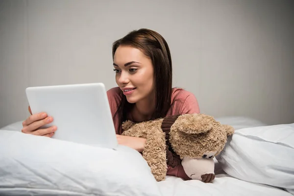 Mujer con tableta en la cama - foto de stock