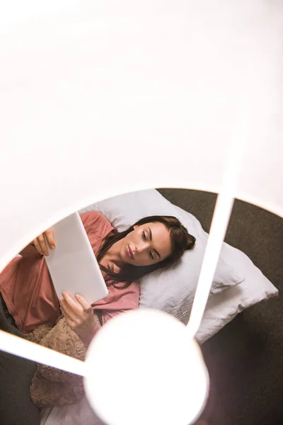 Mujer con tableta en la cama - foto de stock
