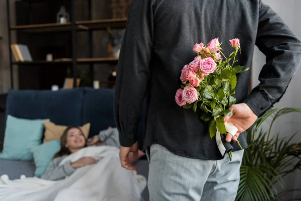 Petit ami cachant bouquet de roses de petite amie sur la journée internationale des femmes — Photo de stock