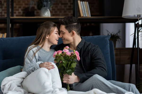 Boyfriend presenting bouquet of roses to happy girlfriend on international womens day — Stock Photo