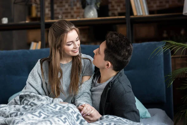 Pareja atractiva mirándose en la cama - foto de stock