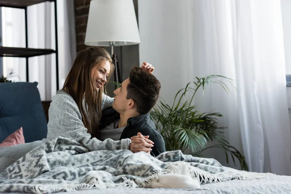 Attraktives Paar, das sich im Bett umarmt und anschaut — Stockfoto