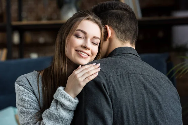 Счастливая девушка обнимает парня с закрытыми глазами — стоковое фото