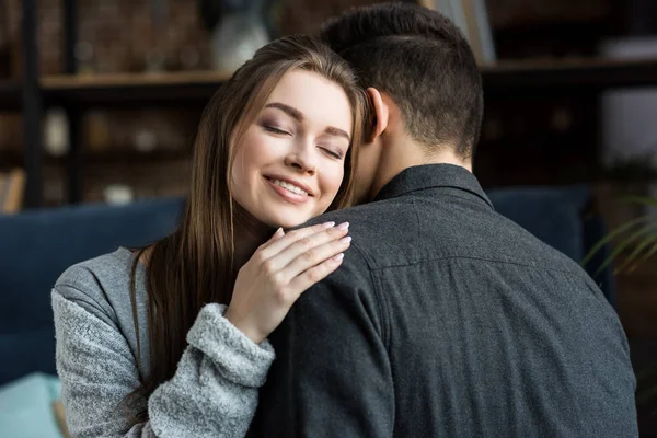 Petite amie heureuse embrasser petit ami avec les yeux fermés — Photo de stock