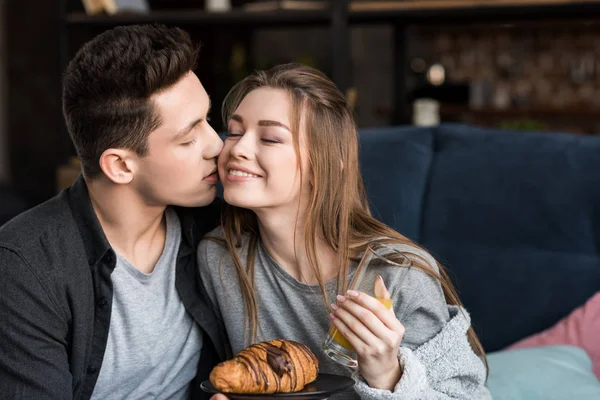 Парень целует подружку во время завтрака — стоковое фото