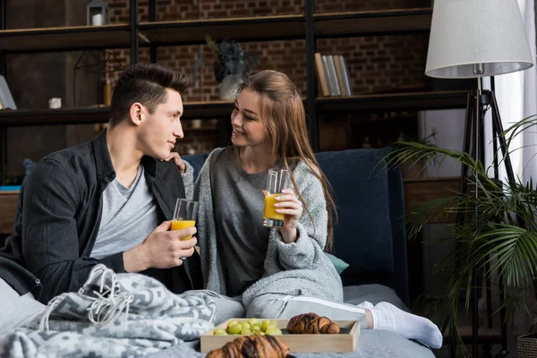 Щаслива пара тримає окуляри з апельсиновим соком під час сніданку — стокове фото