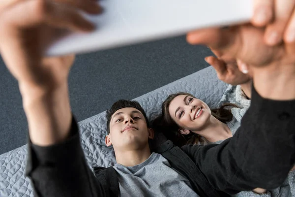 Overhead-Ansicht von Paar, das liegt und auf Tablet schaut — Stockfoto