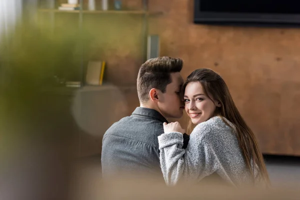 Namorado beijando bela namorada e ela olhando para a câmera — Fotografia de Stock