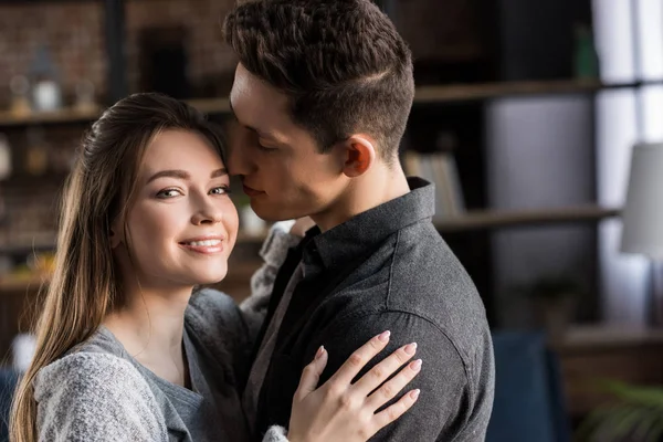 Boyfriend kissing girlfriend and she looking at camera — Stock Photo