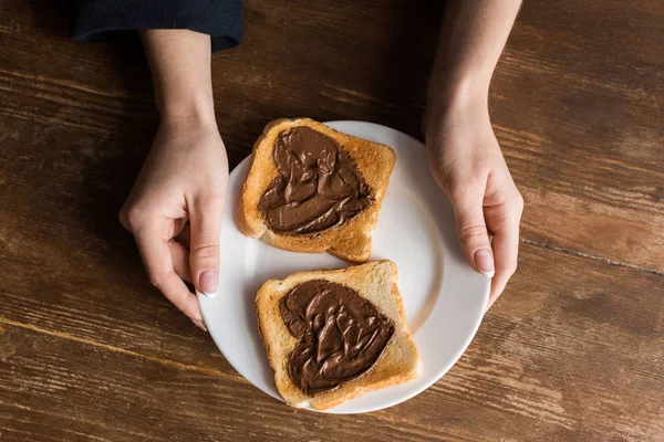 Cropped image of girl holding plate with toasts with hearts, valentines day concept — Stock Photo