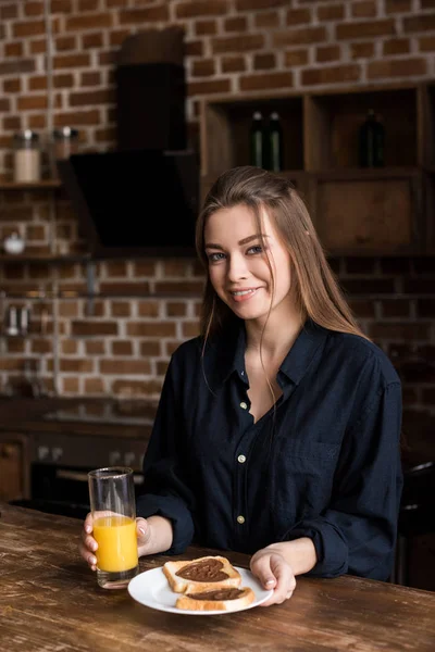 Fille souriante tenant du jus d'orange et regardant la caméra, concept de Saint Valentin — Photo de stock