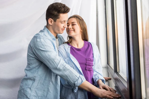 Happy couple going to kiss near window — Stock Photo