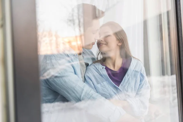 Vista a través de la ventana en pareja va a besar con los ojos cerrados - foto de stock