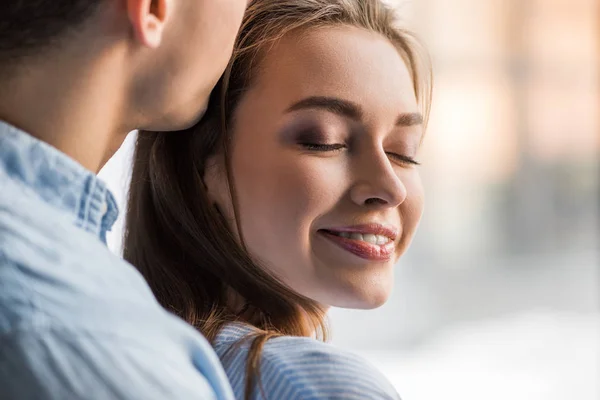 Обрезанный образ парня целующего счастливую девушку — стоковое фото