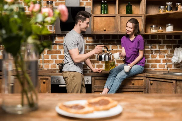 Namorado derramando café em copos na cozinha — Fotografia de Stock