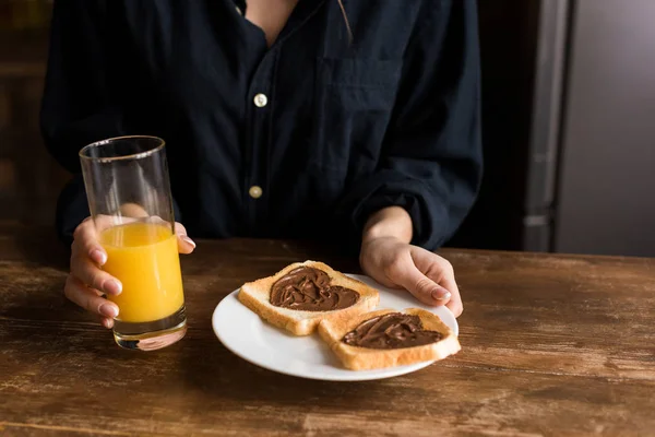 Zugeschnittenes Bild eines Mädchens, das einen Teller mit Toasts mit Herzen aus Schokoladenpaste hält, Valentinstag-Konzept — Stockfoto