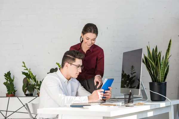 Jóvenes gerentes trabajando juntos en el lugar de trabajo en una oficina moderna - foto de stock