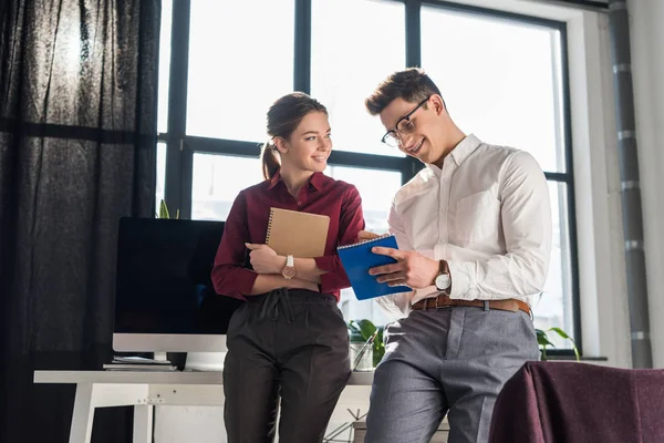 Geschäftspartner lehnen sich am Schreibtisch zurück und besprechen gemeinsam Notizen — Stockfoto