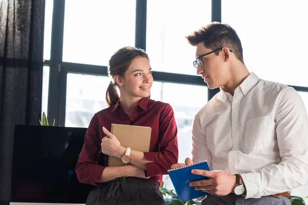 Hermosa joven gerente coqueteando con su colega, concepto de romance de oficina - foto de stock