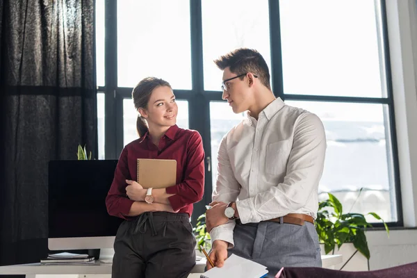 Atractiva joven gerente coqueteando con su colega, concepto de romance de oficina - foto de stock