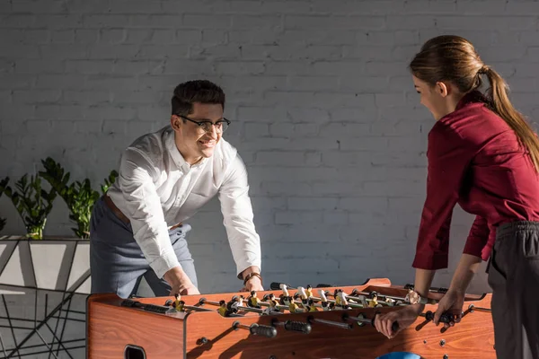 Happy business partners playing table football at modern office — Stock Photo