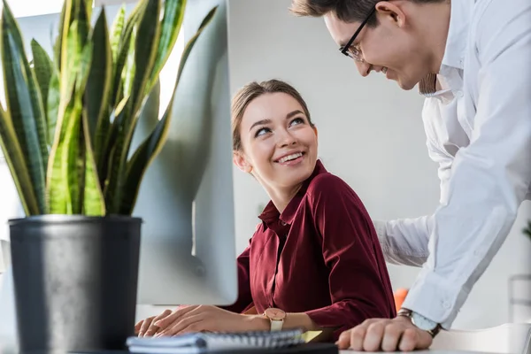 Bel homme d'affaires flirtant avec une collègue féminine au bureau — Photo de stock