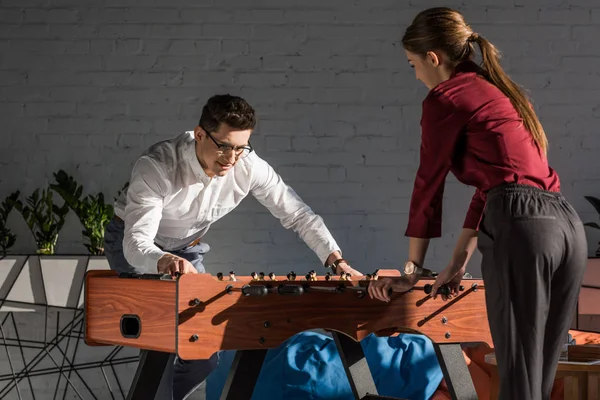 Happy business partners playing kicker at modern office — Stock Photo