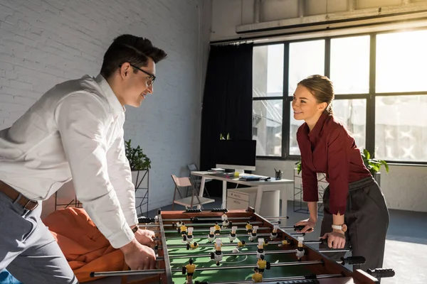 Jeunes partenaires commerciaux jouant au baby-foot au bureau moderne — Photo de stock