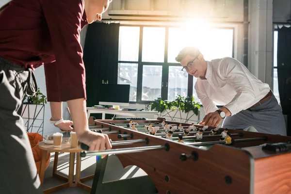 Zufriedene Geschäftsleute beim Tischkicker im modernen Büro — Stockfoto