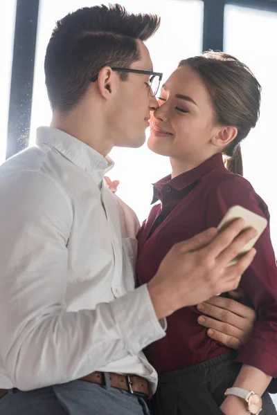 Привабливі поцілунки молода пара в офіційному одязі — стокове фото