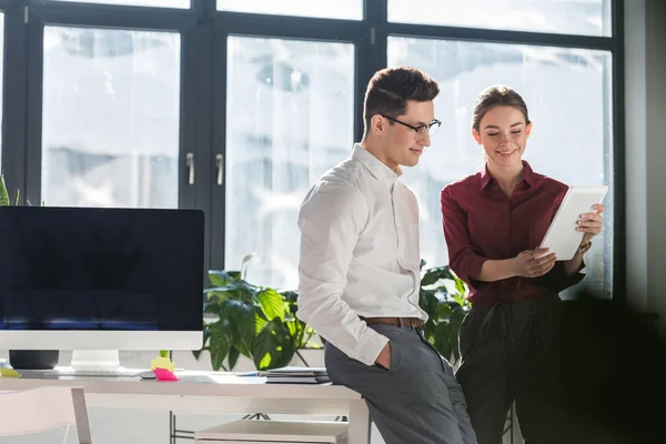 Business partners looking at tablet together at workplace — Stock Photo