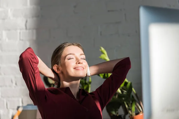 Feliz jovem empresária relaxante no local de trabalho — Fotografia de Stock