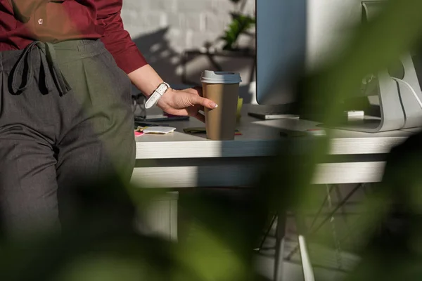 Abgeschnittene Aufnahme einer Geschäftsfrau mit Pappbecher Kaffee, die sich am Schreibtisch zurücklehnt — Stockfoto