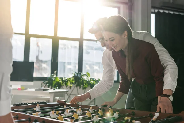 Happy colleagues playing table football together as team — Stock Photo