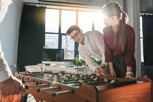 Junge Geschäftspartner spielen gemeinsam Tischkicker im Team — Stockfoto