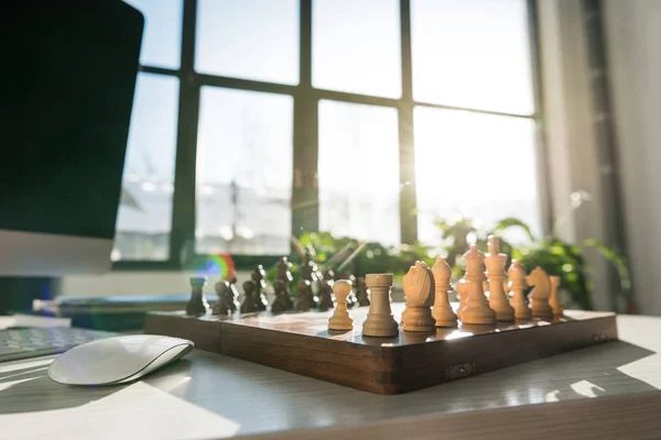 Traditional chess board on workplace against sunshine — Stock Photo