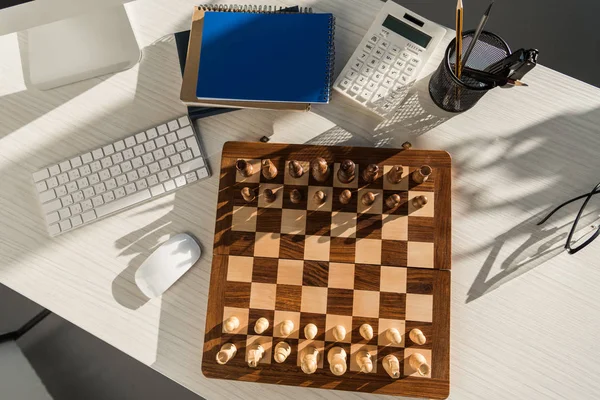 Flat lay chess board at workplace with computer keyboard — Stock Photo