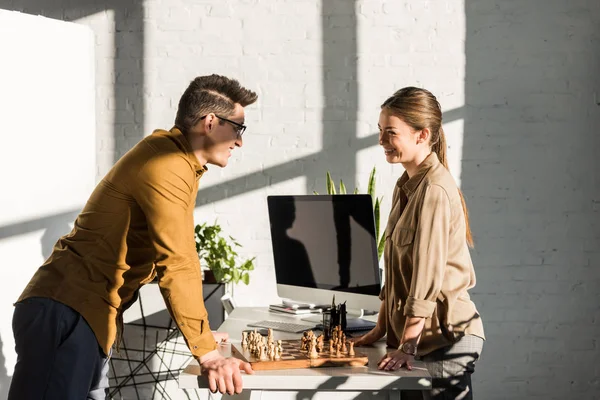 Heureux jeunes collègues jouant aux échecs au bureau — Photo de stock