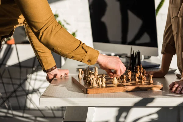 Обрезанный снимок менеджеров, играющих в шахматы на рабочем столе — стоковое фото