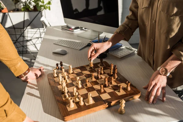 Cropped shot of colleagues playing chess at work desk — Stock Photo