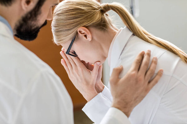 doctor soothing upset colleague 