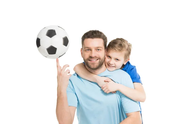 Father and son posing with soccer ball 
