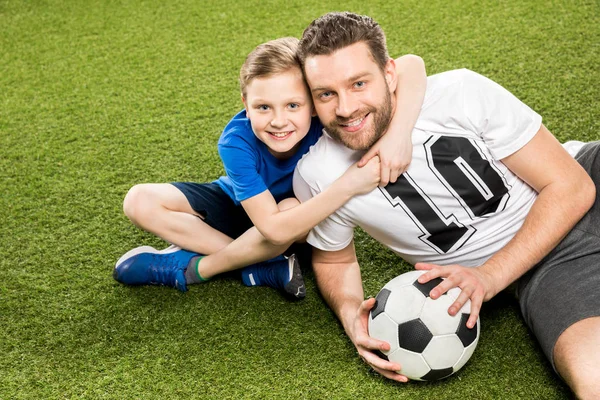 Father and son lying on grass — Stock Photo, Image