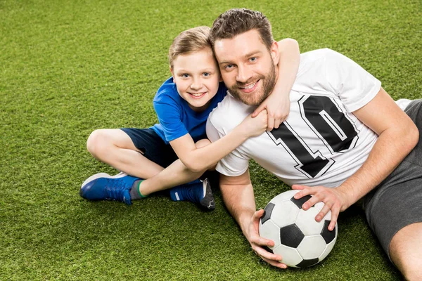 Padre e hijo tendidos en la hierba — Foto de Stock