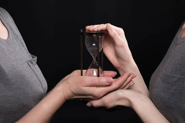 Woman giving hourglass to daughter — Stock Photo, Image