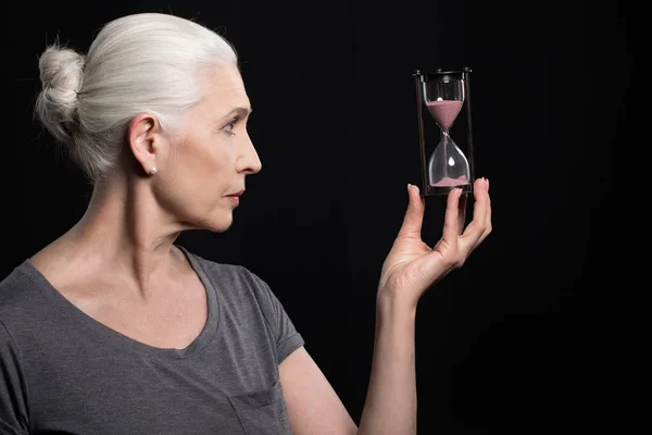 Старша жінка тримає піщаний годинник — стокове фото